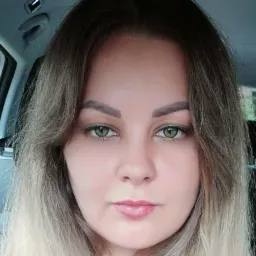 Portret kobiety z zielonymi oczami i blond włosami w samochodzie.