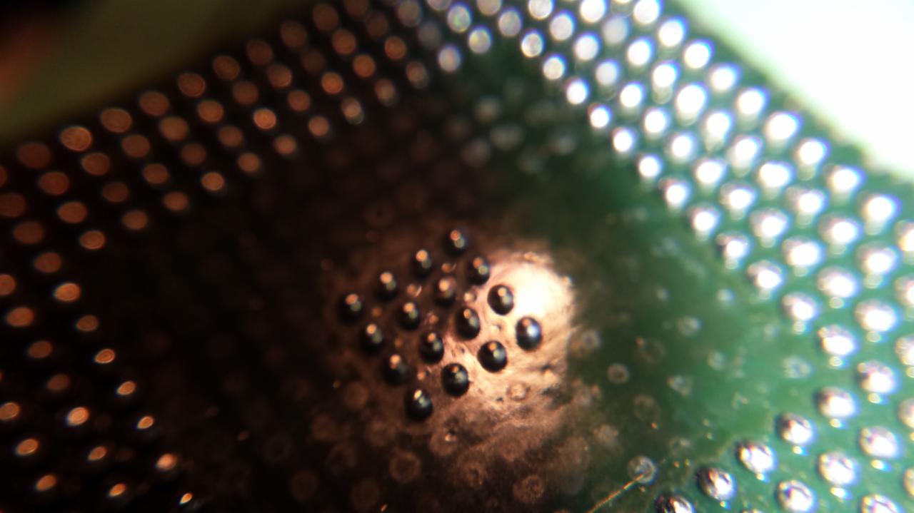 Makro zbliżenie na płytę drukowaną z widocznymi punktami lutowniczymi, ukazujące precyzję wykonania i detale układu elektronicznego.