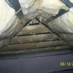 Izolacja poddasza wełną mineralną, widoczne metalowe profile konstrukcyjne, data na zdjęciu 03/13/2012.