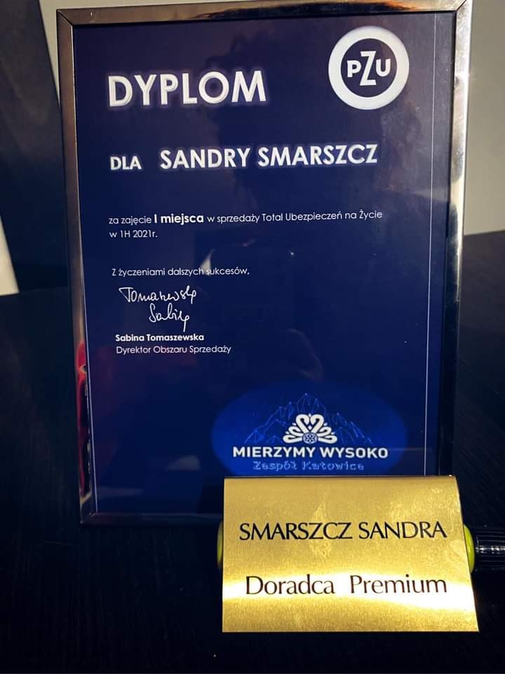 Dyplom dla Sandry Smarszcz za pierwsze miejsce w sprzedaży ubezpieczeń na życie w PZU, wraz z jej złotą plakietką 'Doradca Premium'.