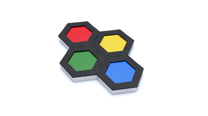 Cztery połączone heksagonalne panele z wypełnieniami w kolorach: czerwonym, żółtym, zielonym i niebieskim, tworzące element placu zabaw.