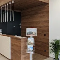 Recepcja w nowoczesnym biurze z drewnianą okładziną ściany, oświetleniem punktowym i stojakiem na ulotki informacyjne.