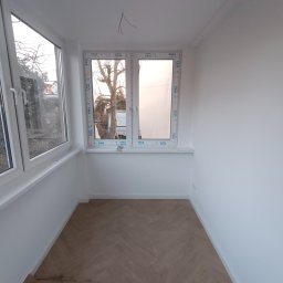 RAF-BUD Rafał Lisek - Jasne wnętrze pokoju po remoncie z nowymi oknami VEKA, świeżo pomalowanymi ścianami na biało i podłogą ułożoną w jodełkę. Widoczne wystające kable ze ściany.