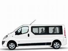 Biały, długi bus Opel Vivaro z przyciemnianymi szybami, widok z boku na jasnym tle.