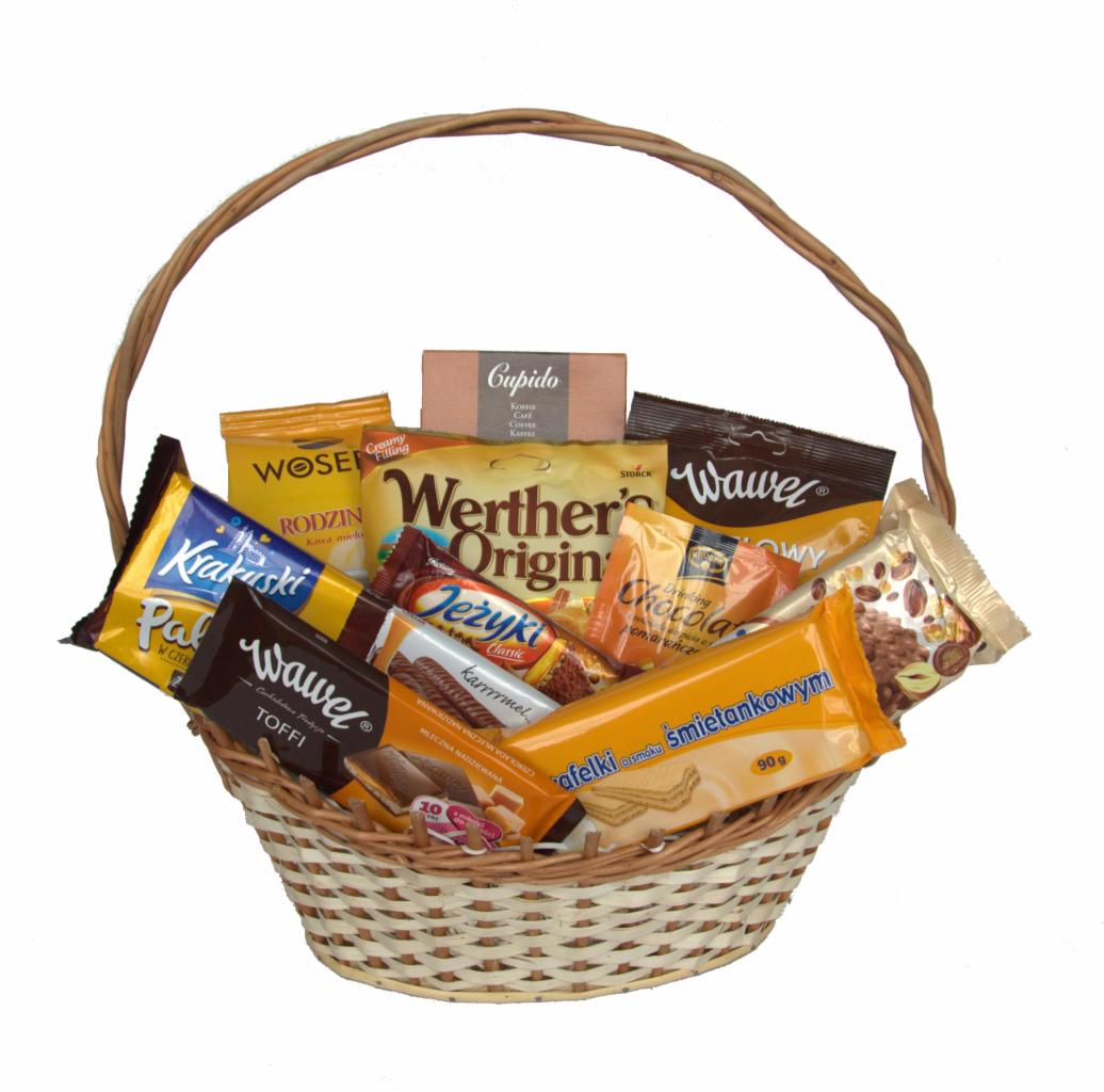 Wiklinowy kosz wypełniony różnorodnymi słodyczami: czekolady, batoniki, cukierki różnych marek, widoczne opakowania Wawel, Werther's Origin, Jeżyki, Krakuski, Cupido, afelki o smaku śmietankowym...