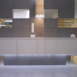 Nowoczesna aranżacja recepcji biurowej z szarymi płytkami, podświetlanym blatem i lustrzanymi wstawkami.