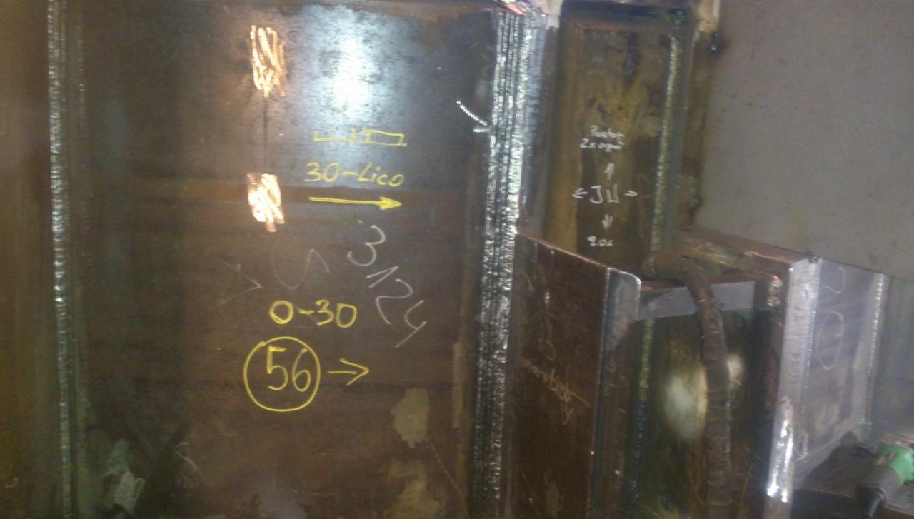 Spoina na metalowej konstrukcji z naniesionymi oznaczeniami technicznymi wykonanymi żółtą kredą.