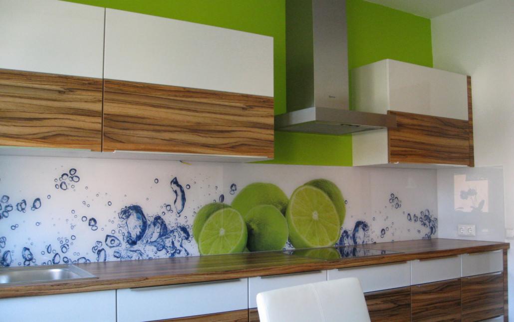 Nowoczesna kuchnia z białymi i drewnianymi szafkami, zieloną ścianą i panelem szklanym z motywem limonek i bąbelków.