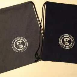 Dwa worki ze sznurkiem w kolorach szarym i granatowym, z białym nadrukiem logo szkoły Liceum Ogólnokształcącego w Łańcucie.