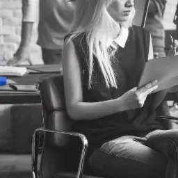 Pracownicy biura w Zawierciu analizują dokumenty w nowoczesnym, częściowo monochromatycznym wnętrzu z akcentami błękitu.