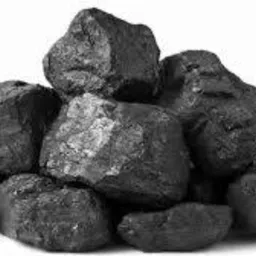 Czarno-białe zdjęcie przedstawia stos brył węgla o nieregularnych kształtach, oświetlonych z lewej strony, z widoczną teksturą i połyskiem na powierzchni.