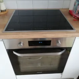 Wbudowany piekarnik elektryczny z płytą indukcyjną Samsung w nowoczesnej kuchni, widoczny wyświetlacz z godziną 9:43.