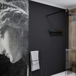 Nowoczesna łazienka z czarną ścianą, kabiną prysznicową z elementami drewna, ręcznikiem na wieszaku i abstrakcyjnym portretem na ścianie.