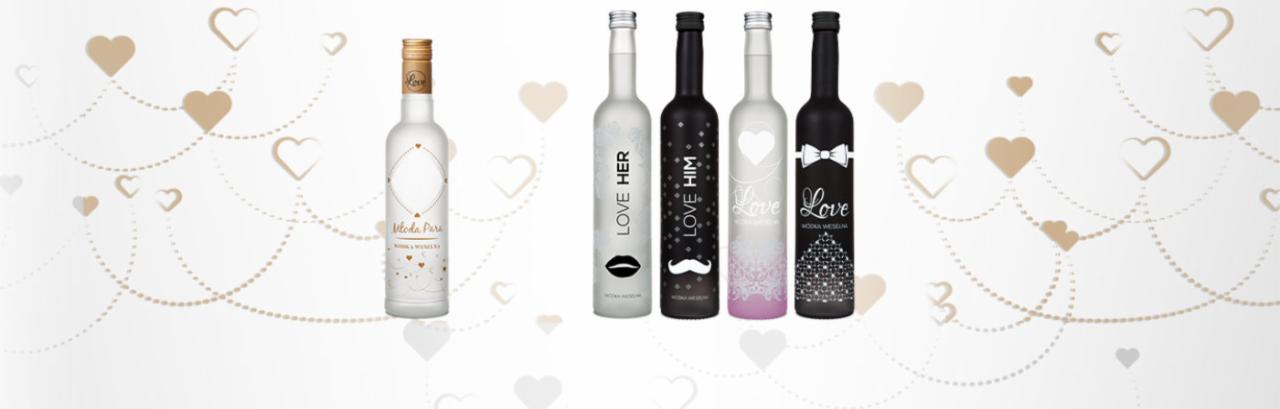 Kolekcja butelek wódki weselnej z motywami miłosnymi i dekoracjami w kształcie serc i kropek na białym tle.