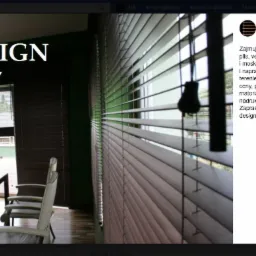 Biuro z drewnianymi żaluzjami poziomymi w kolorze ciemnego brązu, widoczne biurko i krzesła, na ścianie logo firmy JM-DESIGN.