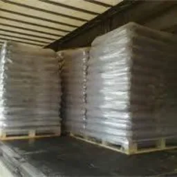 Palety worków z opałem w folii stretch, załadowane w przestrzeni ładunkowej samochodu dostawczego.