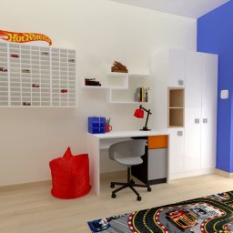 MAKAREWICZ Projekt - Wizualizacja pokoju dziecięcego z biurkiem, regałem na zabawki Hot Wheels, czerwoną pufą i dywanem z motywem wyścigowym.