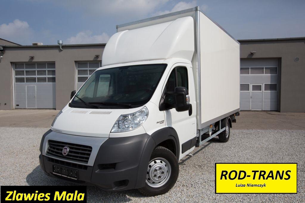 Biały samochód dostawczy Fiat Ducato z zabudową kontenerową na żwirowym placu, logo ROD-TRANS w prawym dolnym rogu.