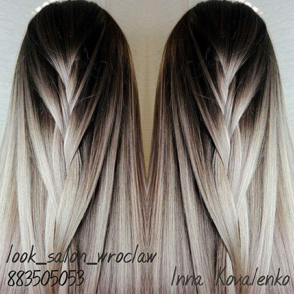 Długie, ombre włosy z zaplecionym warkoczem, stylizacja z ciemnych odrostów przechodząca w chłodny blond, widoczne logo salonu i imię stylistki.