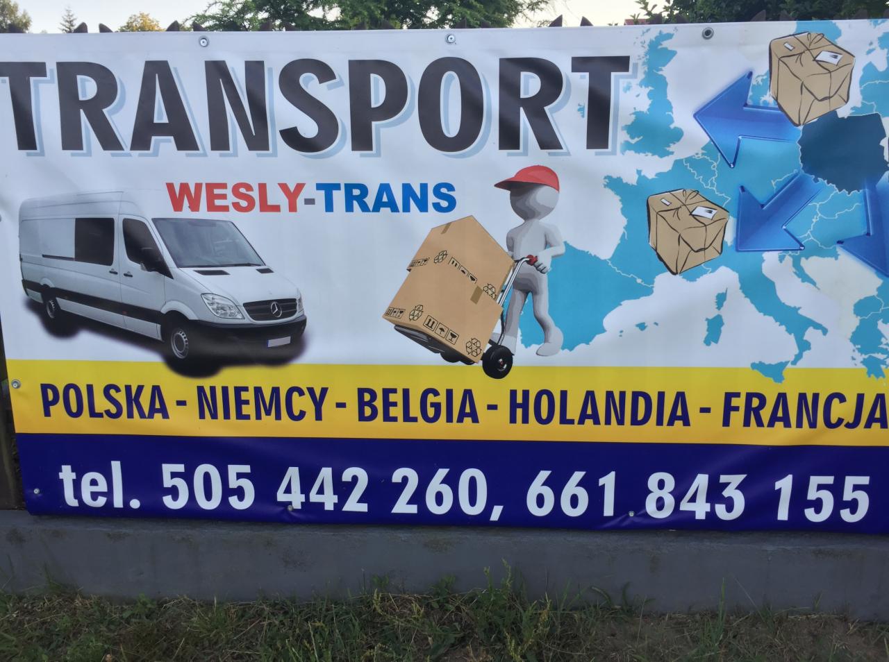 Baner reklamowy firmy transportowej Wesly-Trans z białym busem, mapą Europy z zaznaczonymi krajami docelowymi (Polska, Niemcy, Belgia, Holandia, Francja) oraz animowaną postacią przewożącą karton...