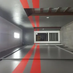 Wnętrze szarego pokoju z czerwonymi pasami na ścianach i suficie, widoczne okno z białymi ramami i drewniana konstrukcja sufitu.