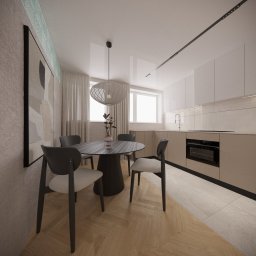 Katarzyna Gruca PROJEKTOWANIE - Wnętrze jasnej kuchni z okrągłym stołem, krzesłami i wiszącą lampą. Na ścianie abstrakcyjny obraz. Parkiet ułożony w jodełkę. Widoczne szklane luksfery w górnej części ściany.