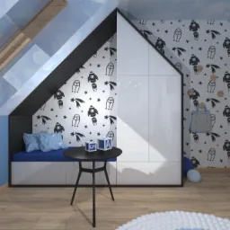 Pokój dziecięcy na poddaszu z zabudową w kształcie domku, tapetą w rakiety, niebieską kanapą z poduszkami, okrągłym stolikiem i drewnianą podłogą.