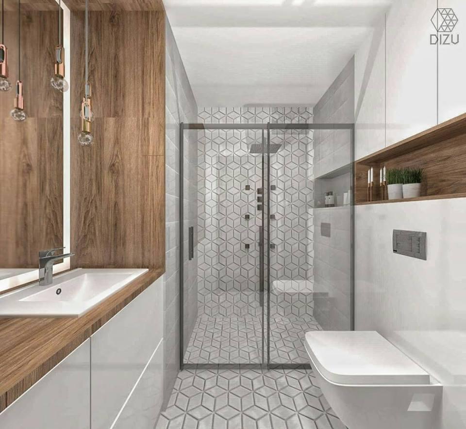 Nowoczesna łazienka z kabiną prysznicową w geometryczne wzory, drewnianym blatem pod umywalką i półką, minimalistycznym oświetleniem oraz wiszącą toaletą.
