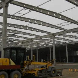 Konstrukcja stalowa hali w Kostrzynie, widoczna żółta równiarka, data 17.11.2013.