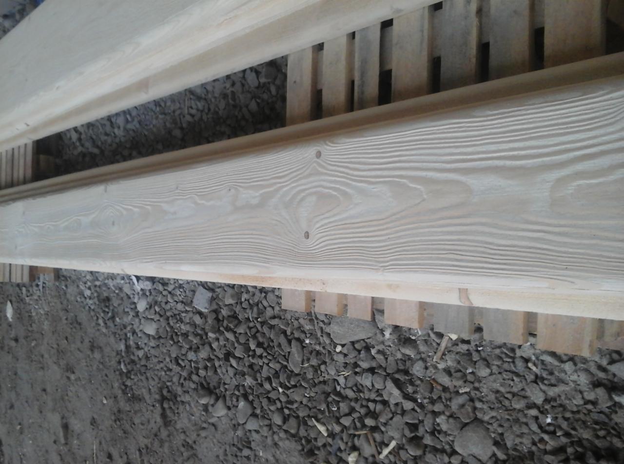 Dwie drewniane belki po obróbce, leżące na podłożu z kamieni, Skomielna Czarna.