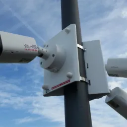 Zestaw trzech kamer monitoringu marki Dahua zamontowanych na słupie na tle błękitnego nieba z chmurami.