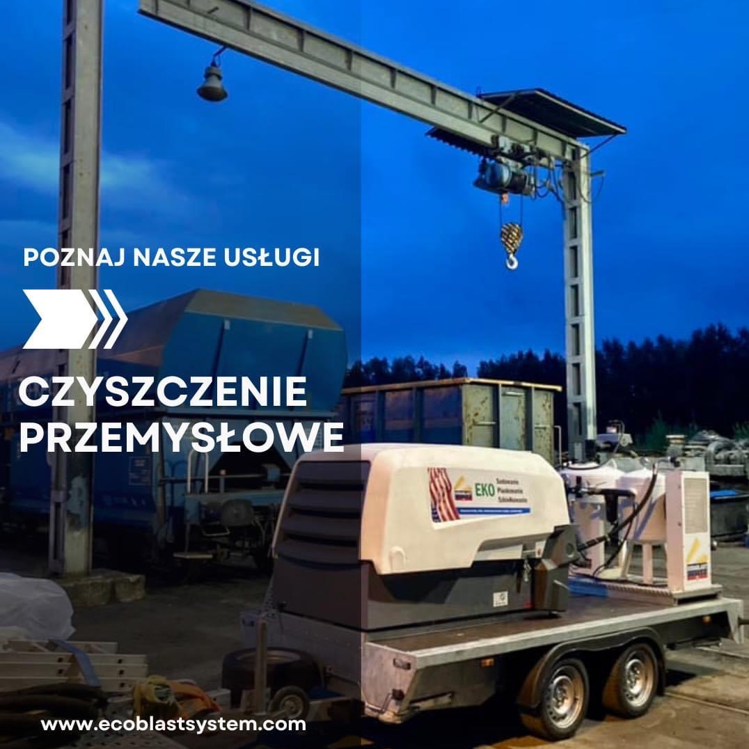 Agregat czyszczący EKO na przyczepie z widoczną konstrukcją suwnicy, w tle wagon kolejowy i kontener, prezentacja firmy oferującej usługi.