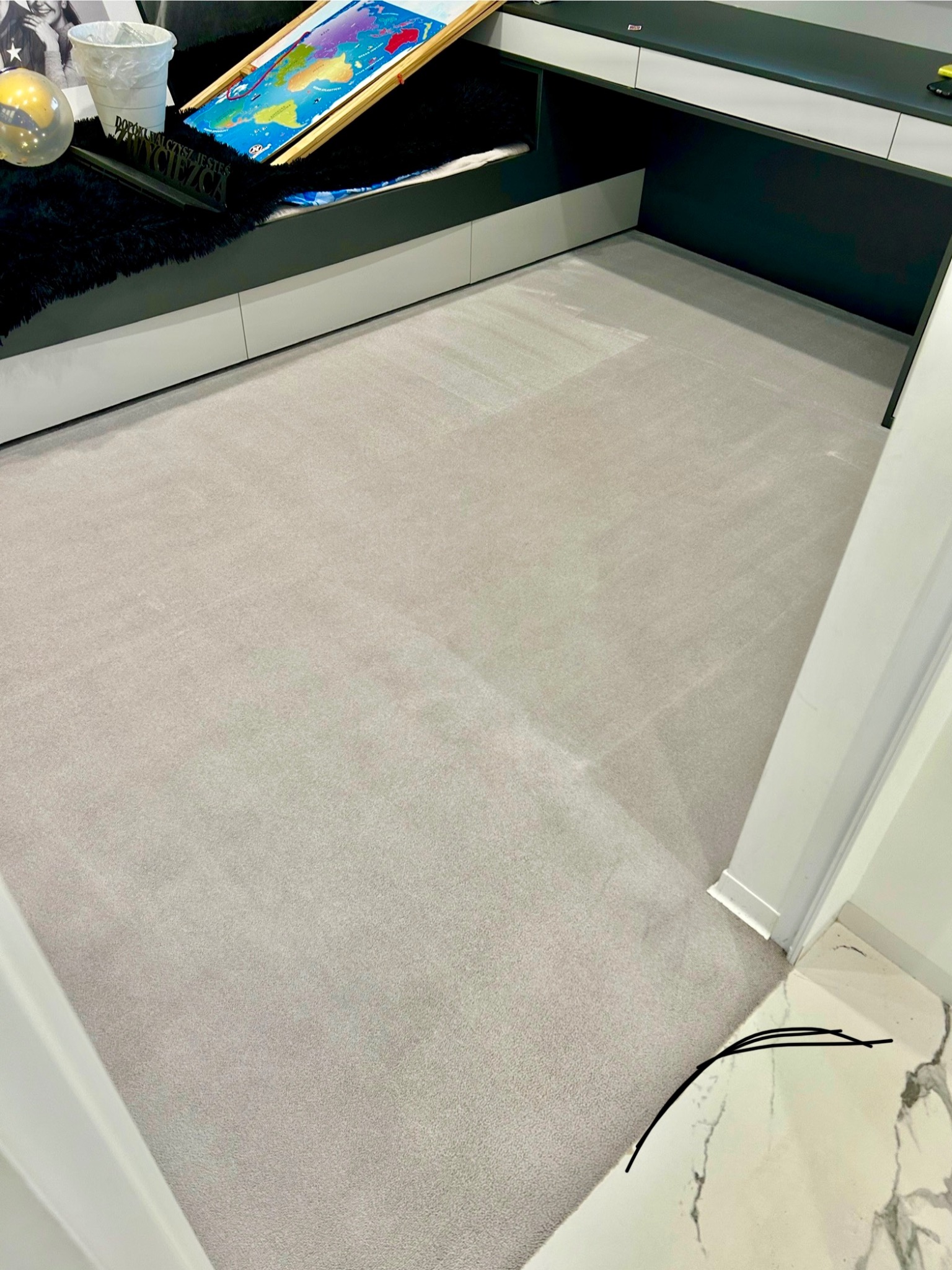Jasnoszary dywan po czyszczeniu, widoczny w pokoju dziecięcym z białymi meblami i czarnymi akcentami, minimalne ślady użytkowania.