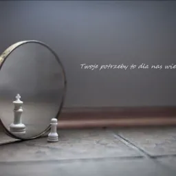 Szachowy król odbija się w lustrze, obok pionek, napis 'Twoje potrzeby to dla nas wielkie zobowiązanie...'