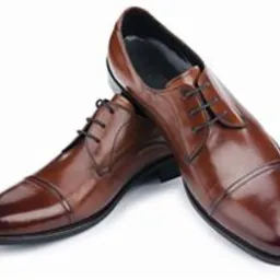 Para brązowych, skórzanych butów wizytowych z czarnymi sznurówkami, ustawionych obok siebie na białym tle, z widocznym połyskiem skóry.