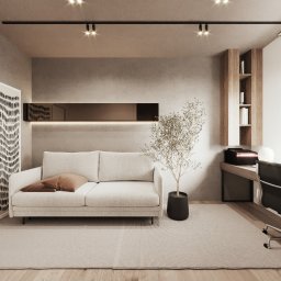 MADO DESIGN - Beżowy salon z biurkiem, na którym stoi komputer z wyświetloną datą 8:31, biała sofa z brązową poduszką, czarne oświetlenie szynowe i roślina w czarnej doniczce.