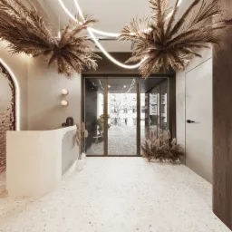 Jasne, nowoczesne wnętrze biura z recepcją, dekoracjami z suszonych traw i neonowym oświetleniem sufitowym, widok na ulicę przez przeszklone drzwi.