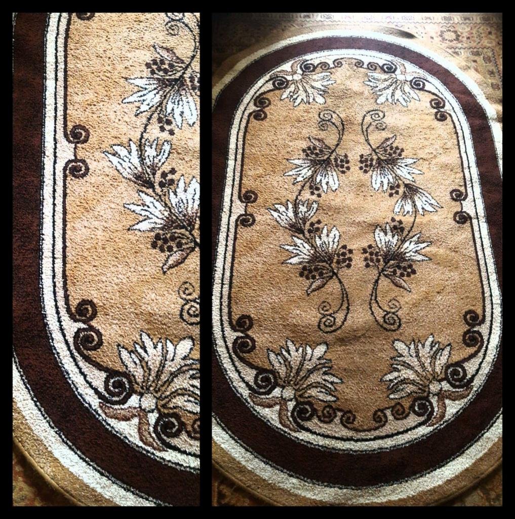 Owalny dywan w odcieniach beżu i brązu z symetrycznym wzorem kwiatowym i spiralnymi ornamentami, ujęcie z góry.