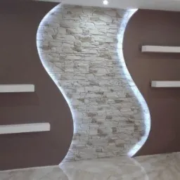 Brązowa ściana z dekoracyjnym, podświetlanym panelem z kamienia w kształcie litery S oraz trzema białymi półkami