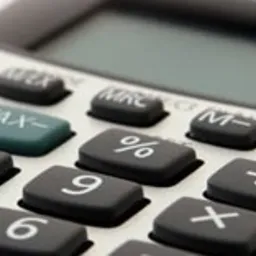 Zbliżenie na klawiaturę kalkulatora biurowego z widocznymi przyciskami funkcyjnymi i numerycznymi, w jasnej tonacji.