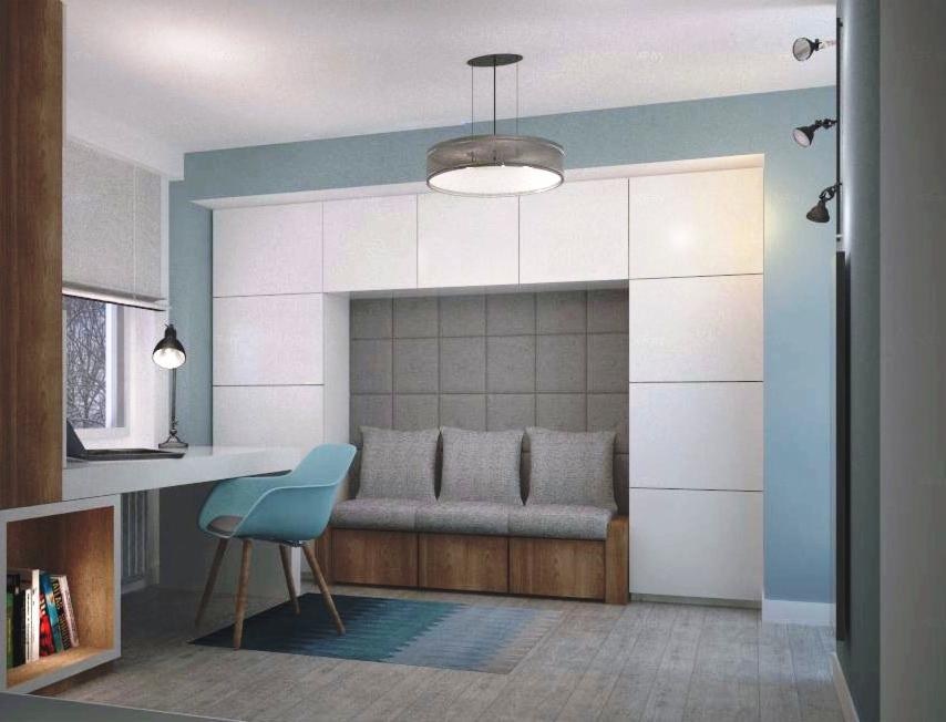 Pokój z biurkiem, turkusowym krzesłem, zabudową meblową z wnęką z siedziskiem i szarą tapicerowaną ścianą, oświetlony lampą wiszącą i kinkietami.