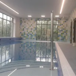 Nowo wykafelkowany basen wewnętrzny z mozaiką w odcieniach niebieskiego, zieleni i bieli, widoczna drabina i wiadro z farbą sugerujące prace wykończeniowe.