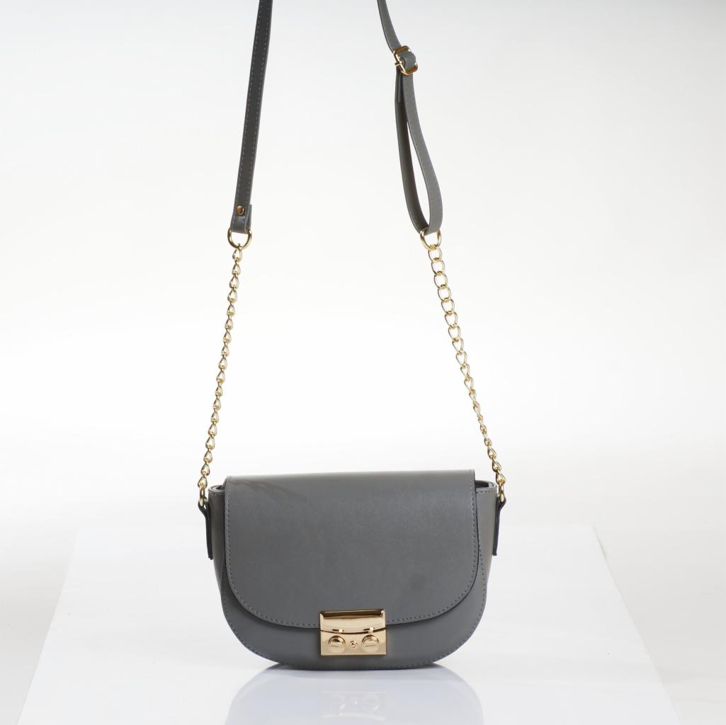 Szara, półokrągła torebka damska z klapką i złotym zapięciem, zawieszona na cienkim pasku i złotym łańcuszku, na białym tle.