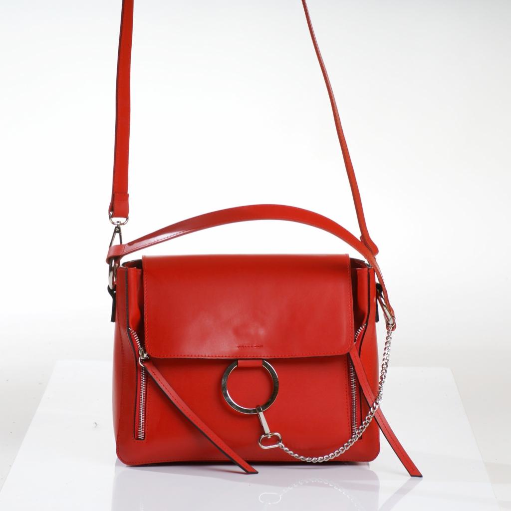 Czerwona skórzana torebka damska z srebrnymi detalami (zamek, łańcuszek, okrągłe zapięcie) na białym tle, wykonana w Częstochowie.