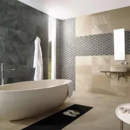 Elegancka łazienka z wolnostojącą wanną i mozaiką. Ciemne płytki imitujące kamień na ścianie, jasne płytki na podłodze i ścianie z umywalką. Nowoczesny design.