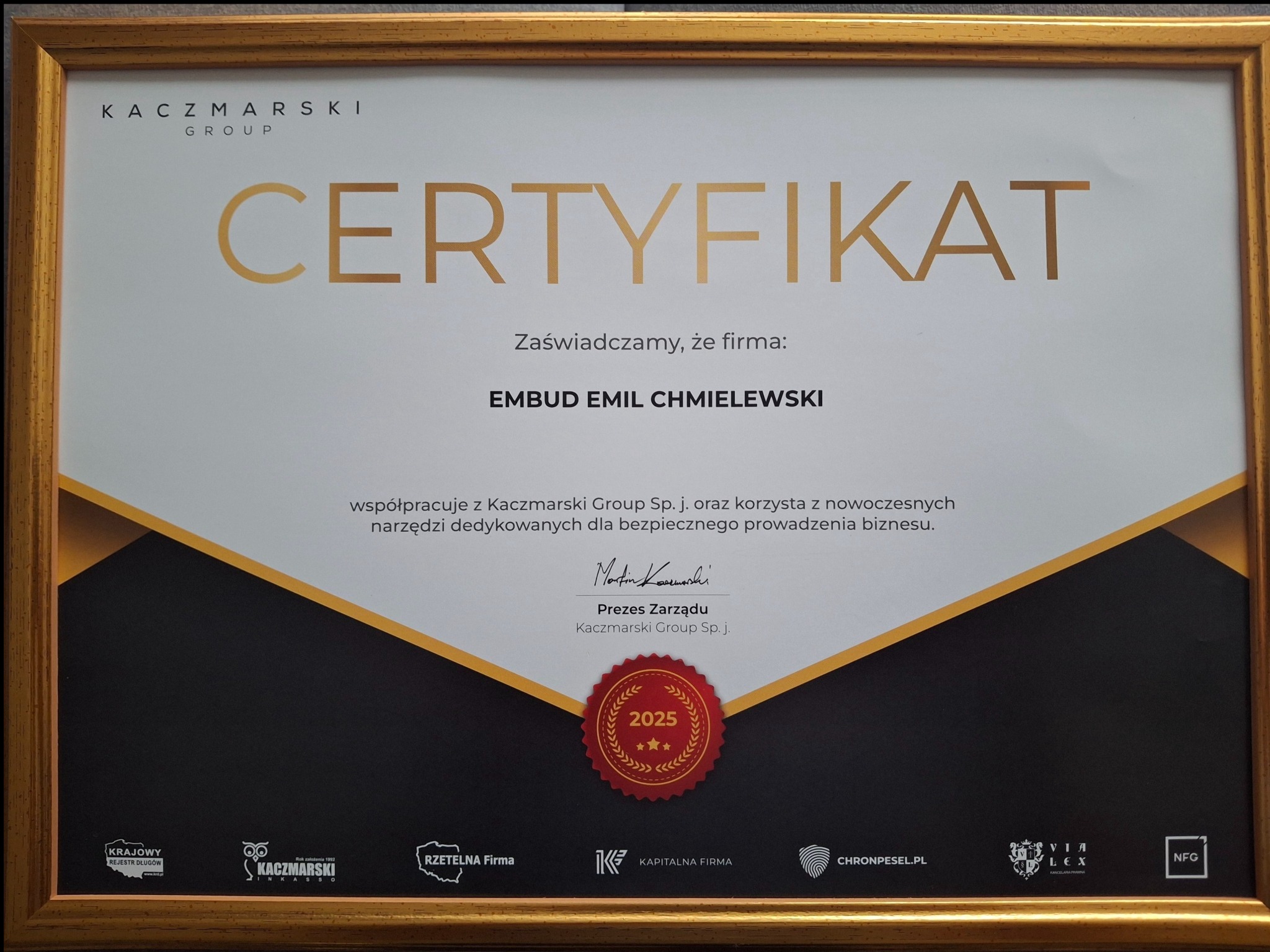 Certyfikat firmy Embud Emil Chmielewski od Kaczmarski Group Sp. j. w złotej ramie, potwierdzający współpracę i korzystanie z nowoczesnych narzędzi biznesowych.