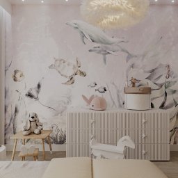 MORGAN INTERIOR DESIGN Andrzej Złoto - Pokój dziecięcy z motywem morskim: tapeta z delfinami, komoda z gwiazdkami, lampa w kształcie chmury, stolik z krzesełkami i zabawki. Przytulne wnętrze.