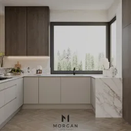 Nowoczesna kuchnia w beżach z marmurowymi akcentami, oświetleniem LED pod szafkami i widokiem na las za oknem, prezentuje minimalistyczny design.