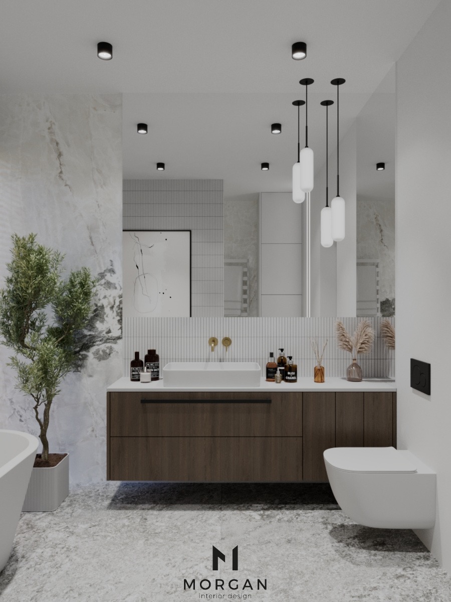 Nowoczesna łazienka z marmurową ścianą, drewnianą szafką pod umywalką, wiszącą toaletą i dekoracyjnym drzewkiem w doniczce, oświetlona wiszącymi lampami.