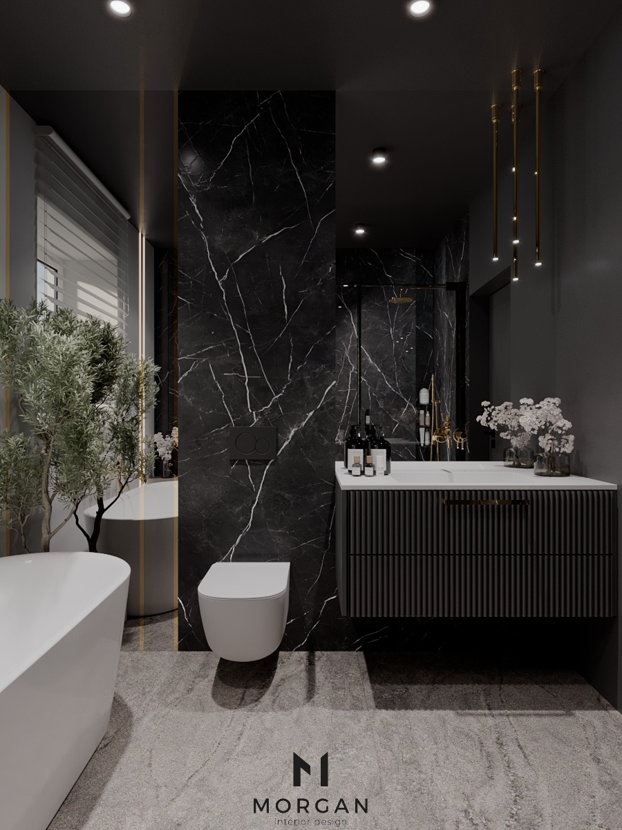 Nowoczesna łazienka w odcieniach szarości i czerni z marmurową ścianą, podwieszaną toaletą, minimalistyczną umywalką z szafką o ryflowanych frontach, wolnostojącą wanną i dekoracyjną rośliną w donicy.